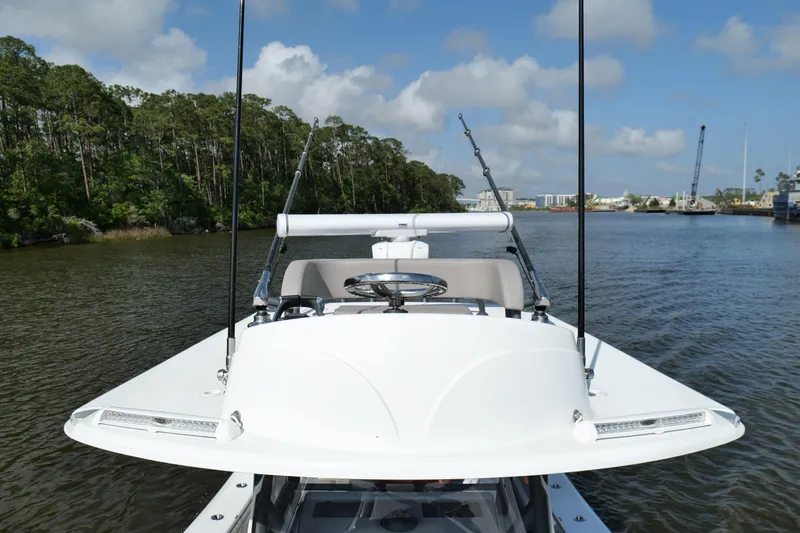 Warranty X Trailer Yacht Photos Pics 2022 Yellowfin 34 Offshore boat navigating a scenic river with lush greenery.