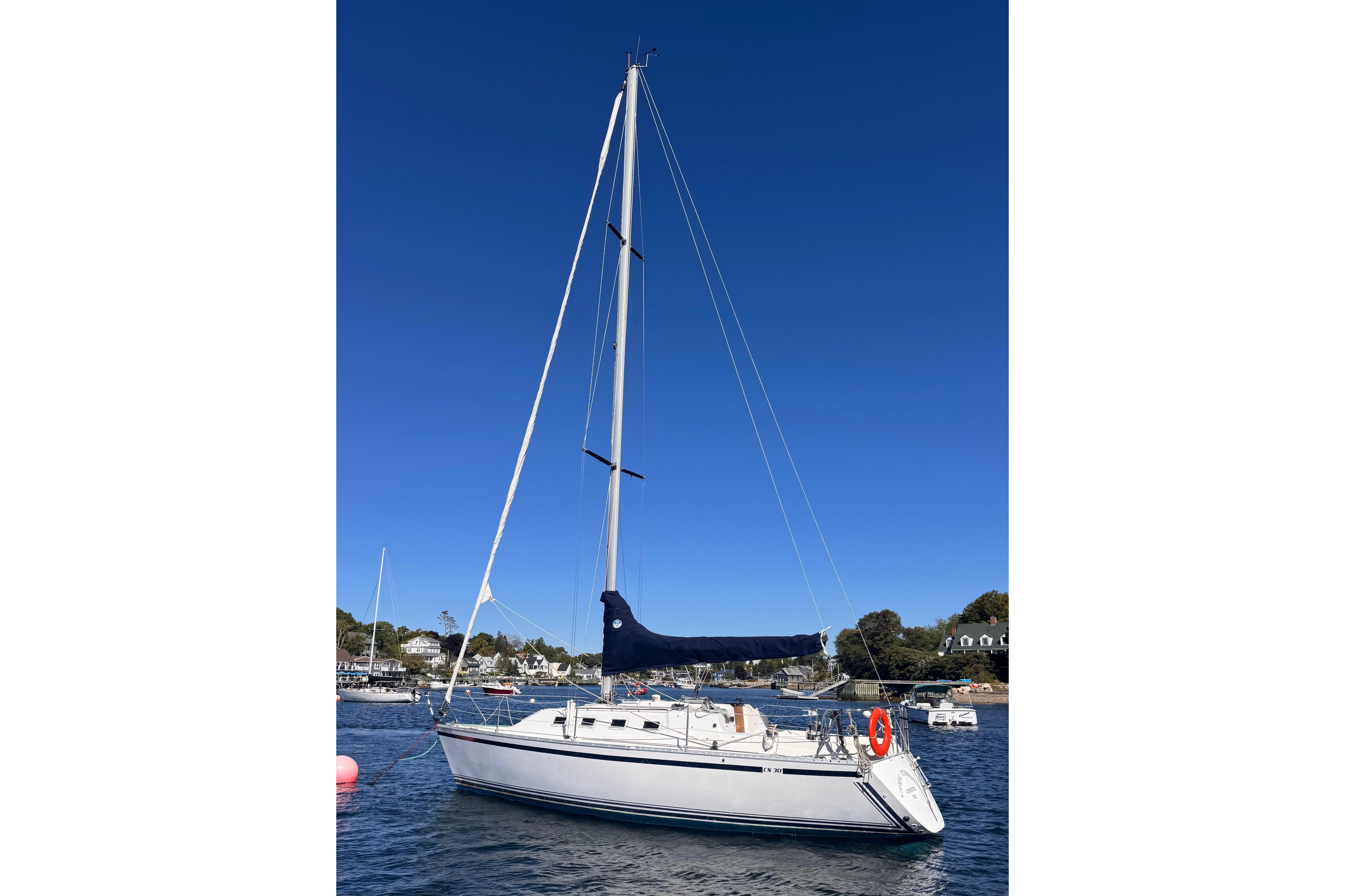 1986 CS 30 sailboat on calm water under clear blue sky.