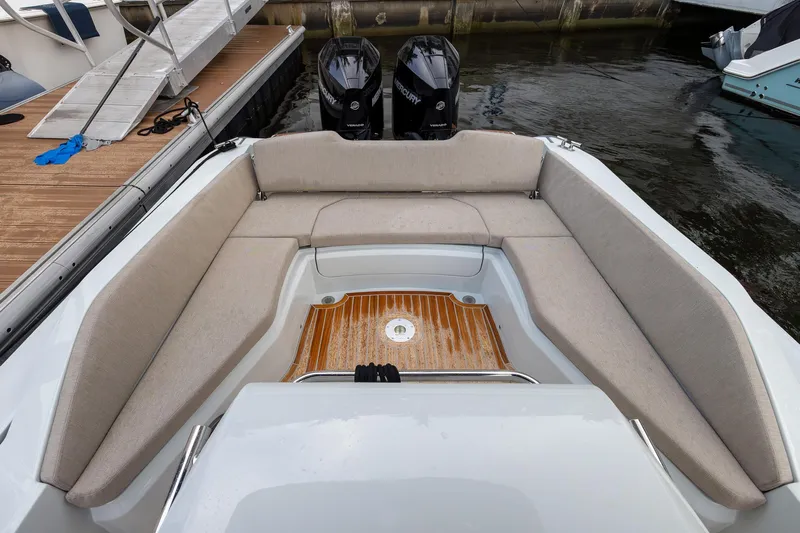  Yacht Photos Pics 2024 SACS Strider 900 boat interior with cushioned seating and wooden deck.