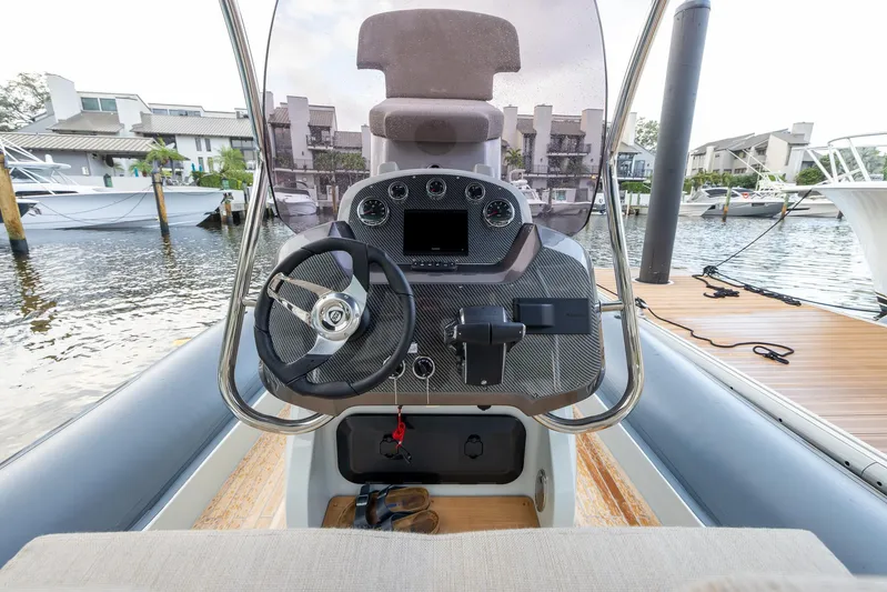 Yacht Photos Pics 2024 SACS Strider 900 boat dashboard with steering wheel, docked at marina.