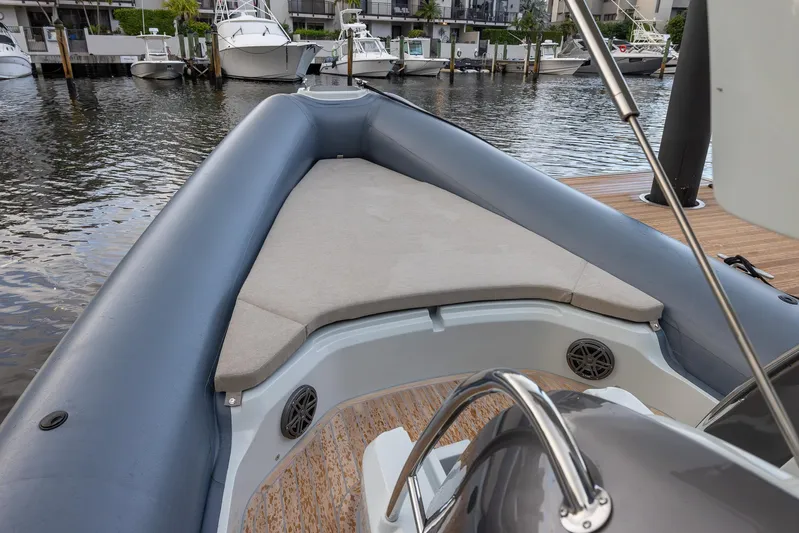  Yacht Photos Pics 2024 SACS Strider 900 boat interior with cushioned seating, docked by the water.