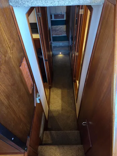 Steel Leader Yacht Photos Pics Interior hallway of 1990 Bayliner 4588 Motoryacht with wooden paneling and carpeted stairs.
