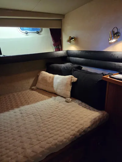 Steel Leader Yacht Photos Pics Cozy cabin interior of 1990 Bayliner 4588 Motoryacht with bed and porthole window.