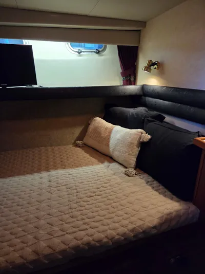 Steel Leader Yacht Photos Pics Cozy cabin interior of 1990 Bayliner 4588 Motoryacht with bed and porthole window.