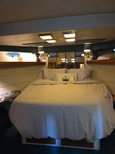 Steel Leader Yacht Photos Pics Luxurious bedroom interior of 1990 Bayliner 4588 Motoryacht with cozy bedding and elegant lighting.