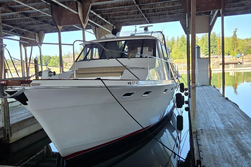 Steel Leader Yacht Photos Pics 1990 Bayliner 4588 Motoryacht docked in a covered marina, reflecting on calm water.