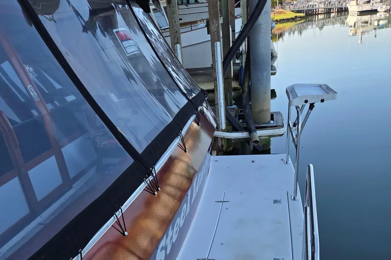 Steel Leader Yacht Photos Pics 1990 Bayliner 4588 Motoryacht docked, featuring clear canopy and calm water reflection.