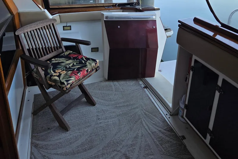 Steel Leader Yacht Photos Pics 1990 Bayliner 4588 Motoryacht interior with wooden chair and tropical cushion.