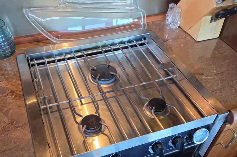 Steel Leader Yacht Photos Pics Stainless steel stove on Bayliner 4588 Motoryacht, 1990 model, with three burners and control knobs.