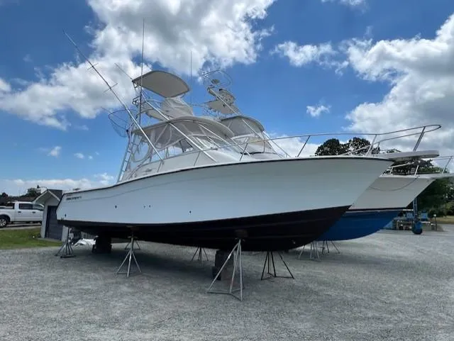 The Big O Yacht Photos Pics 2002 Grady-White 330 Express boat on stands under a partly cloudy sky.