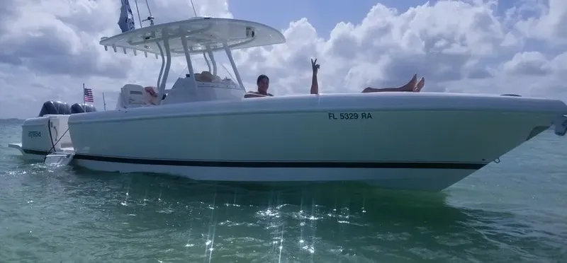  Yacht Photos Pics 2016 Intrepid 327 Center Console boat on water, people relaxing onboard, sunny day.