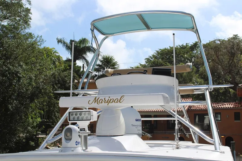 Maripal Yacht Photos Pics 2008 Contender 38 Express boat with canopy and radar equipment, docked near tropical foliage.