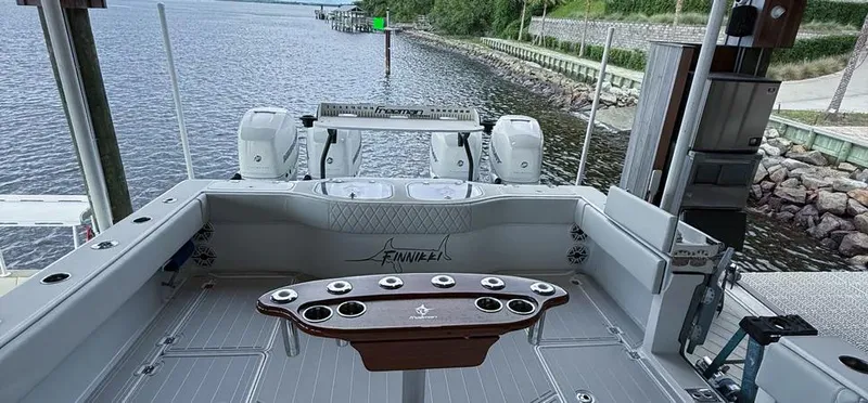  Yacht Photos Pics 2019 Freeman 42 LR boat interior with fishing rod holders, docked by a calm waterfront.
