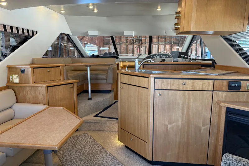 Touchdown Yacht Photos Pics Interior of 2000 Bayliner 3988 Command Bridge Motoryacht with wood cabinetry and seating area.