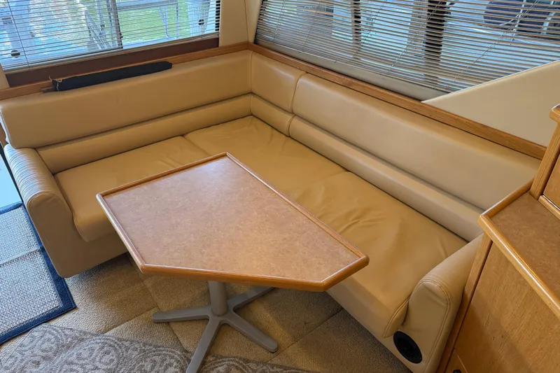 Touchdown Yacht Photos Pics Luxurious interior of 2000 Bayliner 3988 Command Bridge Motoryacht with beige seating and table.