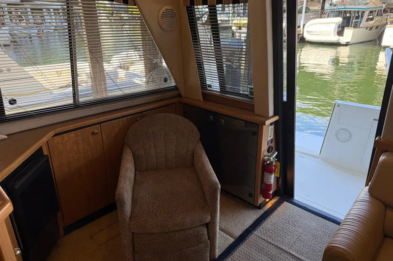 Touchdown Yacht Photos Pics Interior of 2000 Bayliner 3988 Command Bridge Motoryacht with chair, window, and open door to deck.