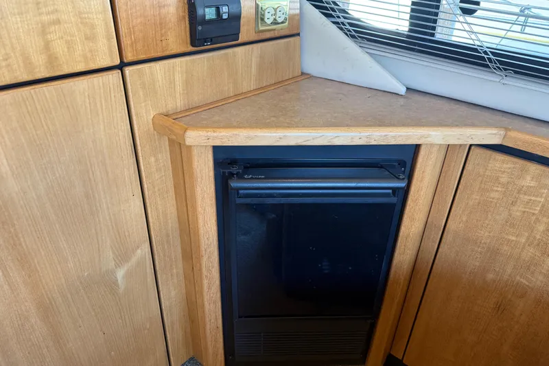 Touchdown Yacht Photos Pics Wooden interior of 2000 Bayliner 3988 Command Bridge Motoryacht with compact fridge and countertop.