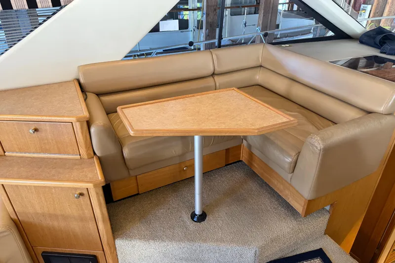 Touchdown Yacht Photos Pics 2000 Bayliner 3988 Command Bridge Motoryacht interior with beige leather seating and wooden table.