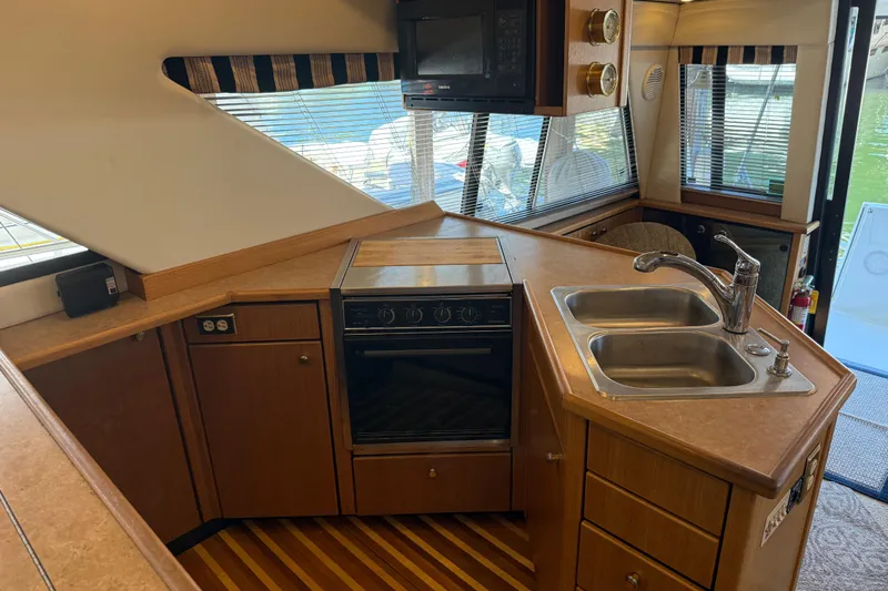 Touchdown Yacht Photos Pics Interior of 2000 Bayliner 3988 Command Bridge Motoryacht kitchen with sink, stove, and microwave.