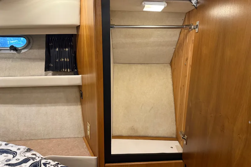 Touchdown Yacht Photos Pics Interior of 2000 Bayliner 3988 Command Bridge Motoryacht with wooden closet and porthole window.