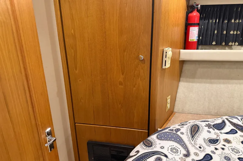 Touchdown Yacht Photos Pics Interior of 2000 Bayliner 3988 yacht with wood paneling, fire extinguisher, and paisley bedding.