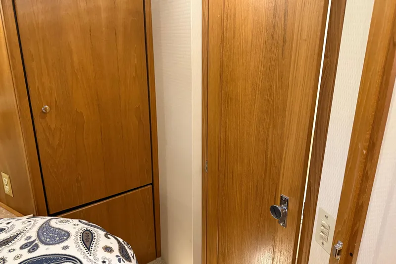 Touchdown Yacht Photos Pics Wooden interior of 2000 Bayliner 3988 Command Bridge Motoryacht with paisley-patterned bedding.