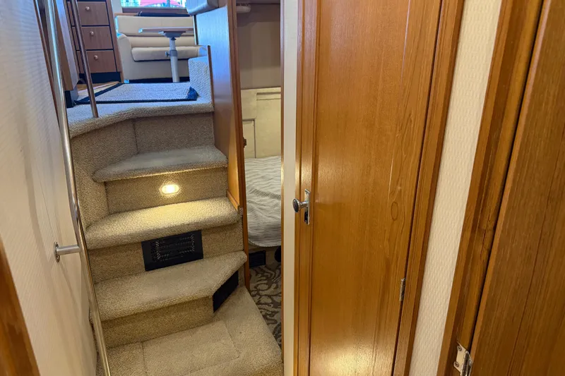 Touchdown Yacht Photos Pics Interior of 2000 Bayliner 3988 Command Bridge Motoryacht with carpeted stairs and wooden doors.