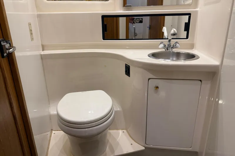 Touchdown Yacht Photos Pics 2000 Bayliner 3988 Command Bridge Motoryacht bathroom with toilet, sink, and storage cabinet.
