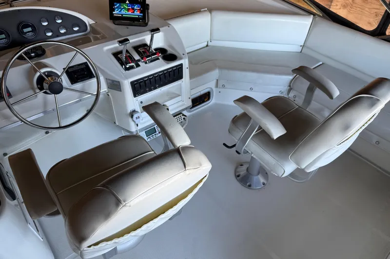 Touchdown Yacht Photos Pics 2000 Bayliner 3988 Command Bridge Motoryacht helm with dual seats and navigation controls.