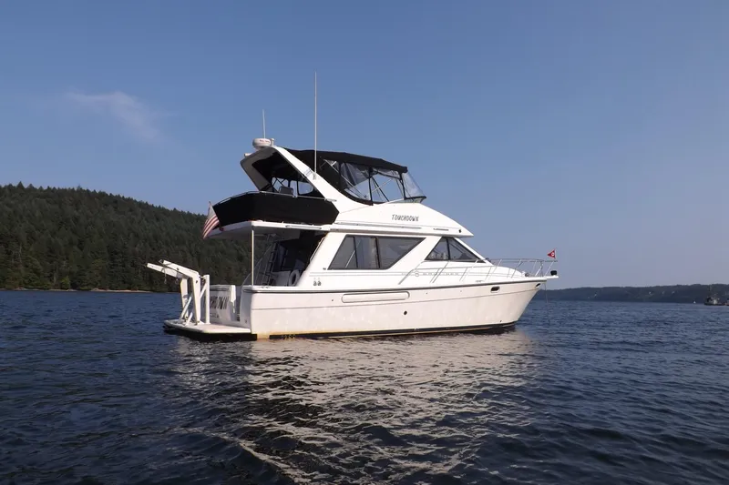 Touchdown Yacht Photos Pics 2000 Bayliner 3988 Command Bridge Motoryacht on serene lake with forested shoreline.