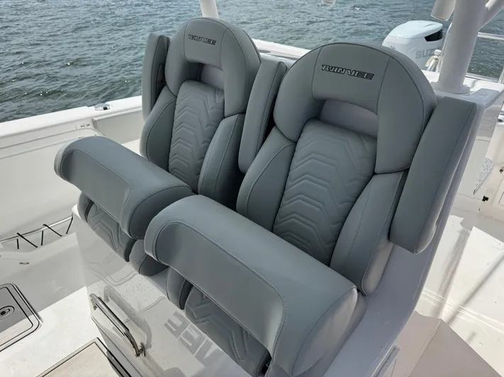 Katatak Yacht Photos Pics Twin Vee 280 GFX CC 2023 boat seats with gray upholstery on a sunny day.