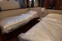 Twin beds in a 2010 Aicon 85 yacht cabin, covered in protective plastic.