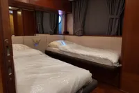 Luxurious cabin interior of 2010 Aicon 85 yacht with twin beds and elegant wood finish.