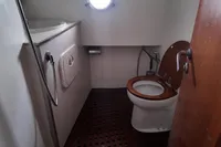 Bathroom interior of 2010 Aicon 85 yacht with wooden toilet seat and porthole window.