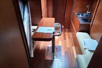 Interior of 2010 Aicon 85 yacht with wooden flooring, table, kitchenette, and seating area.