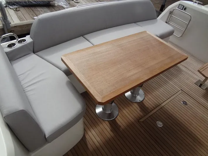  Yacht Photos Pics Prestige 420F 2024 boat interior with wooden table and cushioned seating.