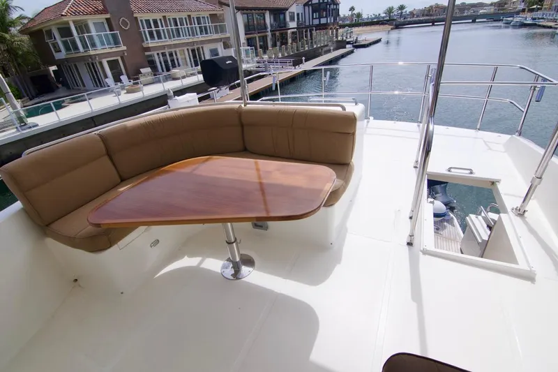 Pangea Yacht Photos Pics Luxurious 2007 Norseman 560 Sedan yacht deck with seating and table, overlooking waterfront homes.