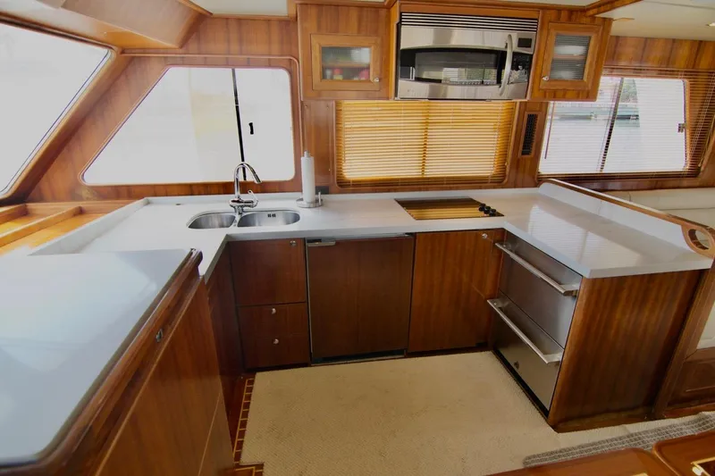 Pangea Yacht Photos Pics Luxurious kitchen interior of 2007 Norseman 560 Sedan yacht with wood finish and modern appliances.