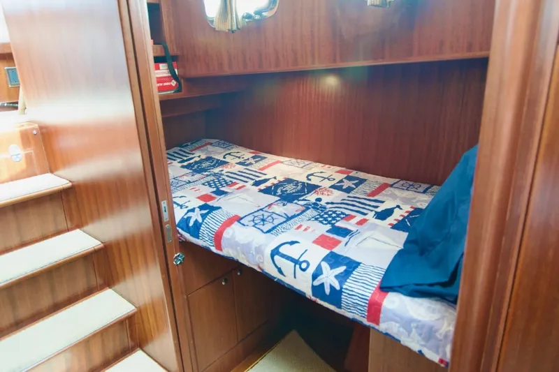 Pangea Yacht Photos Pics Cozy cabin interior of 2007 Norseman 560 Sedan with nautical-themed bedding.