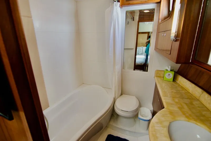 Pangea Yacht Photos Pics Luxurious bathroom in 2007 Norseman 560 Sedan yacht with bathtub and wooden cabinetry.