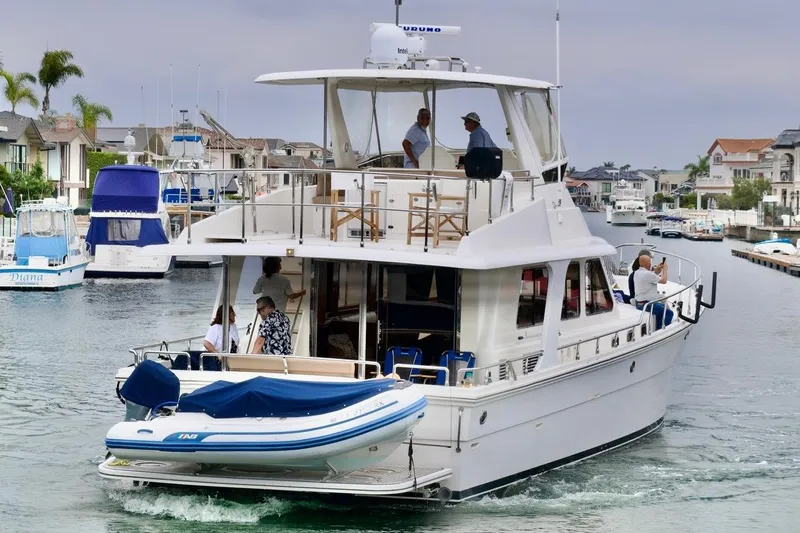Pangea Yacht Photos Pics 2007 Norseman 560 Sedan yacht cruising in a marina with people on board.