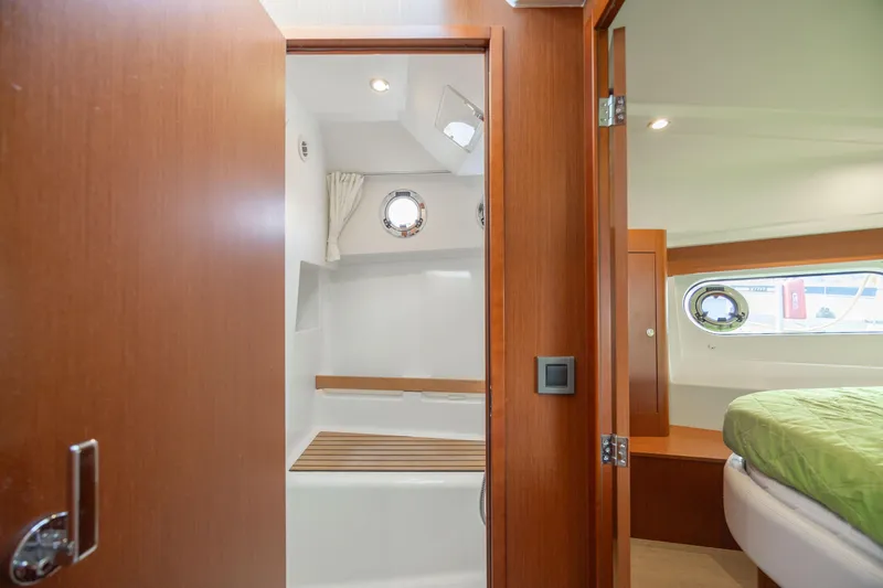 Smooth Yacht Photos Pics Interior of 2019 Beneteau Swift Trawler 30, featuring bathroom and bedroom with porthole windows.