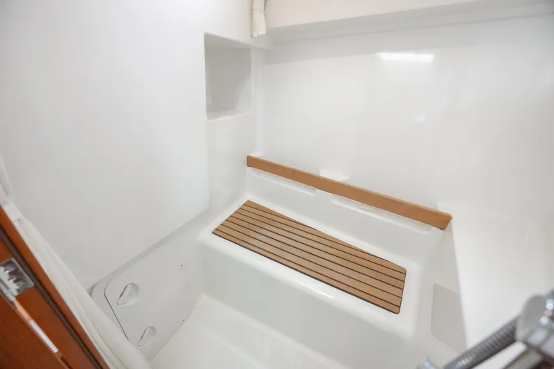 Smooth Yacht Photos Pics 2019 Beneteau Swift Trawler 30 shower area with wooden seat and white interior.
