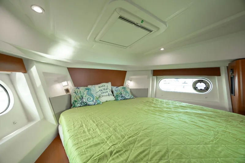 Smooth Yacht Photos Pics 2019 Beneteau Swift Trawler 30 bedroom with green bedding and porthole windows.