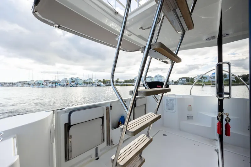 Smooth Yacht Photos Pics 2019 Beneteau Swift Trawler 30, rear deck view with marina backdrop.