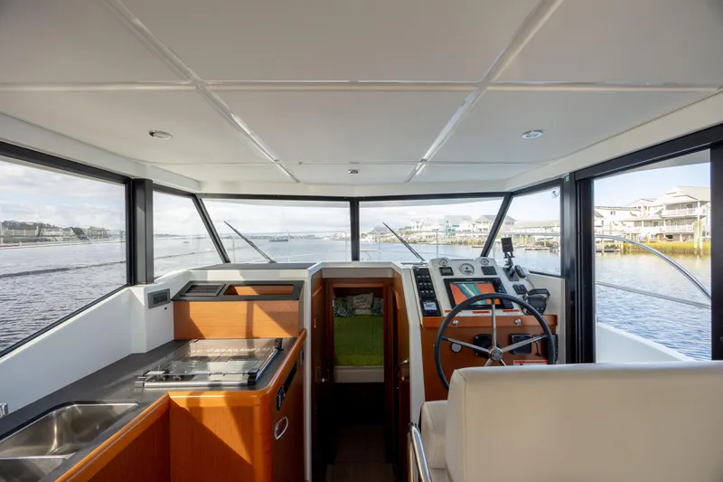 Smooth Yacht Photos Pics Interior view of 2019 Beneteau Swift Trawler 30 helm with panoramic windows.