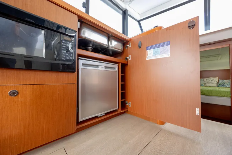 Smooth Yacht Photos Pics 2019 Beneteau Swift Trawler 30 interior kitchen with microwave and open cabinet.