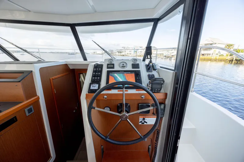 Smooth Yacht Photos Pics 2019 Beneteau Swift Trawler 30 helm with navigation equipment and steering wheel.