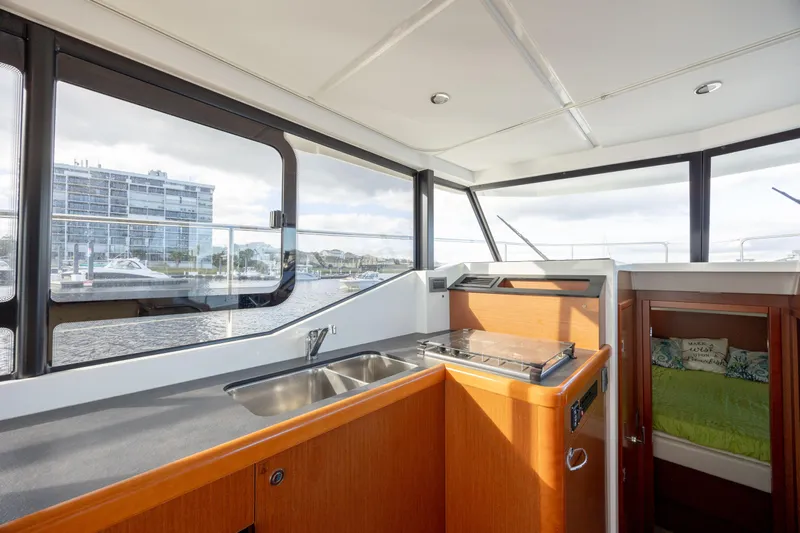 Smooth Yacht Photos Pics 2019 Beneteau Swift Trawler 30 interior with kitchenette and scenic window view.