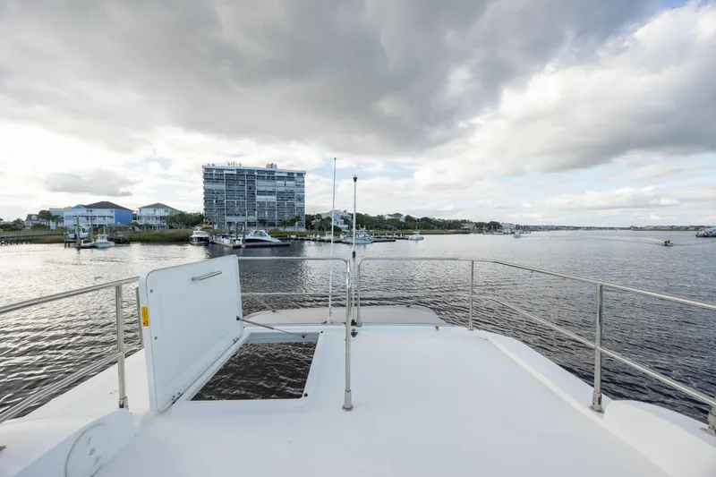 Smooth Yacht Photos Pics View from 2019 Beneteau Swift Trawler 30, overlooking marina and waterfront buildings under cloudy sky.
